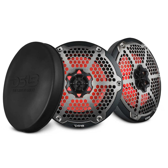 Two DS18 speakers with carbon-fiber-patterned rims, silver honeycomb grilles and red lighting, beside a black protective cover.