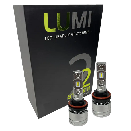 Two metallic Lumi Stage 2 H11 LED Headlight Bulbs, equipped with advanced CSP chips and delivering a crisp 6000K color temperature, are displayed in front of a black Lumi LED Headlight Systems box featuring â€œStage IIâ€ and â€œ2â€ branding.