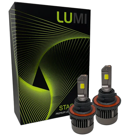 Two LUMI Stage 3 H4 LED Headlight Bulbs by Lumi, featuring metallic bases with cooling fins and visible yellow CSP chips on their flat tops, are positioned in front of a black Lumi box adorned with green and yellow geometric lines.