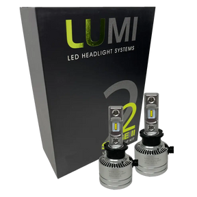 Two premium LUMI Stage 2 H3 LED Headlight Bulbs with advanced CSP chips are positioned in front of a sleek black Lumi LED Headlight Systems box labeled Stage 2, delivering brilliant 6000K color temperature illumination.