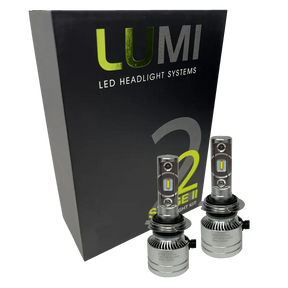 Two LUMI Stage 2 H7 LED Headlight Bulbs from Lumi, featuring advanced CSP chips, are displayed in front of a black box labeled â€œLUMI LED Headlight Systems S2 Stage II Headlight Kitâ€ on a white background, providing bright 6000K illumination for superior visibility.