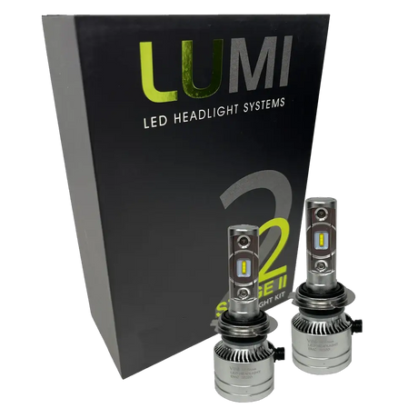 Two LUMI Stage 2 H7 LED Headlight Bulbs from Lumi, featuring advanced CSP chips, are displayed in front of a black box labeled â€œLUMI LED Headlight Systems S2 Stage II Headlight Kitâ€ on a white background, providing bright 6000K illumination for superior visibility.