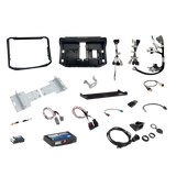 Radio installation components laid out with dashboard panels, mounting brackets, interface modules, wiring harnesses and adapter leads