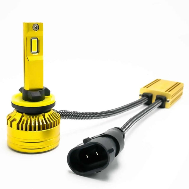 Gold-colored LED bulb with a black collar, yellow ring and round finned base beside an inline module and connector