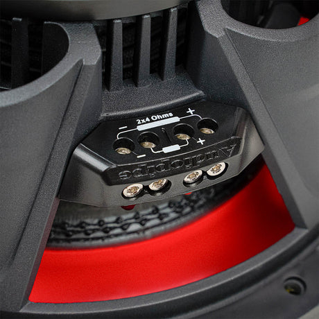 Close-up of a four-terminal subwoofer block marked 2x4 ohms, with positive and negative connection markings