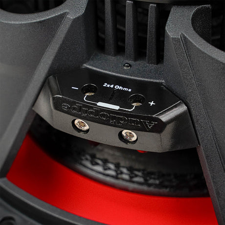 Close-up of a two-terminal subwoofer block marked 2x4 ohms, with positive and negative markings