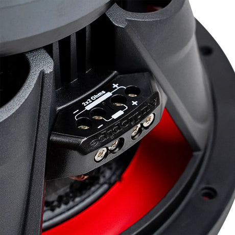 Close-up of an Audiopipe subwoofer terminal block with wiring markings and red suspension behind it