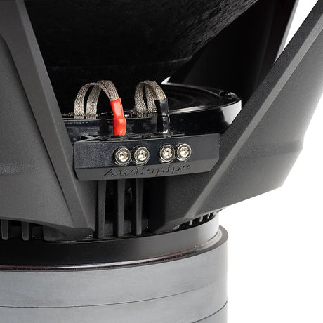 Close-up of an Audiopipe subwoofer terminal block with four screw connections and red and black braided leads