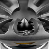 Close-up of an oval speaker's black spoke-pattern grille and bullet-shaped center