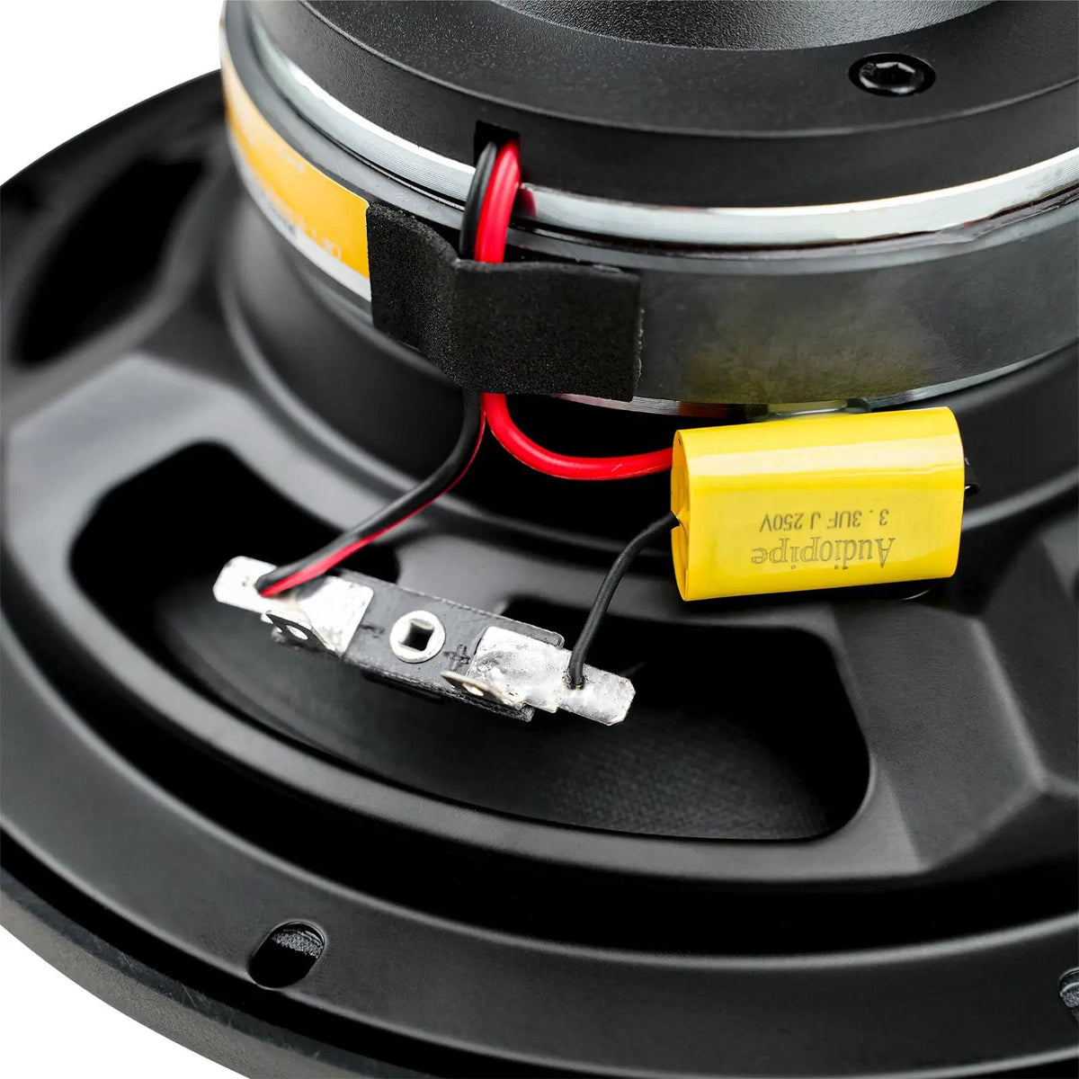 Audiopipe loudspeaker close-up showing its capacitor, terminals and red connecting wire