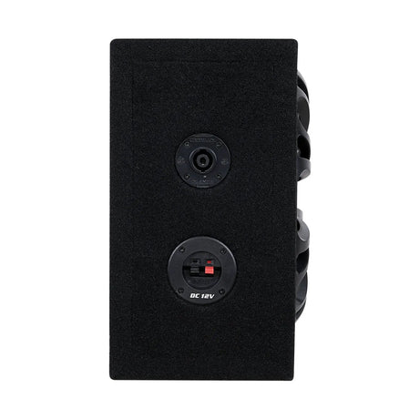 Side of a black-carpeted enclosure with a round socket and red and black DC 12V terminals