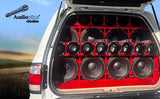 Vehicle audio installation with an open rear door and a wall of red-rimmed speakers and horn drivers