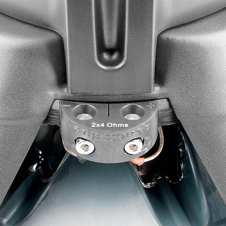 Close-up of an Audiopipe subwoofer terminal block labeled 2x4 Ohms