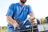 Person using blue-handled wire crimping pliers beside an outdoor metal bracket