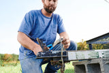 Person using a blue-handled wire crimper and cutter on wiring outdoors