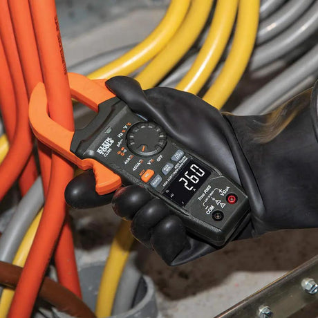 Klein CL390 clamp meter held around an orange conductor, with a 20.0 reading on the display