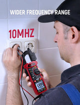 KC604 clamp meter connected to an outlet with test leads in a frequency measurement demonstration