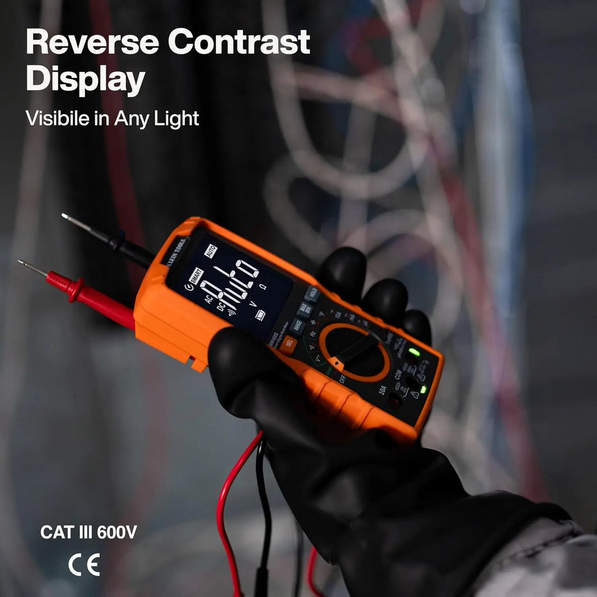 Klein MM460S multimeter held in a gloved hand, demonstrating its illuminated reverse-contrast display