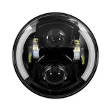 Front view of a round black motorcycle headlight with two projector lenses and partial halo