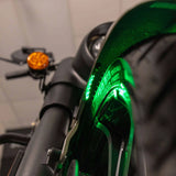 Close-up of green accent lighting beneath a motorcycle fender