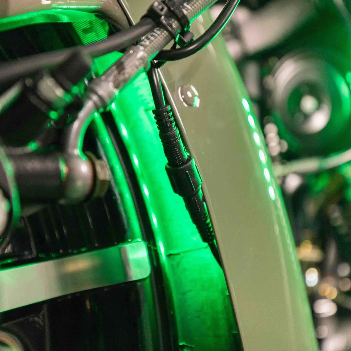 Green LED accent strip and inline connector installed beside the motorcycle engine