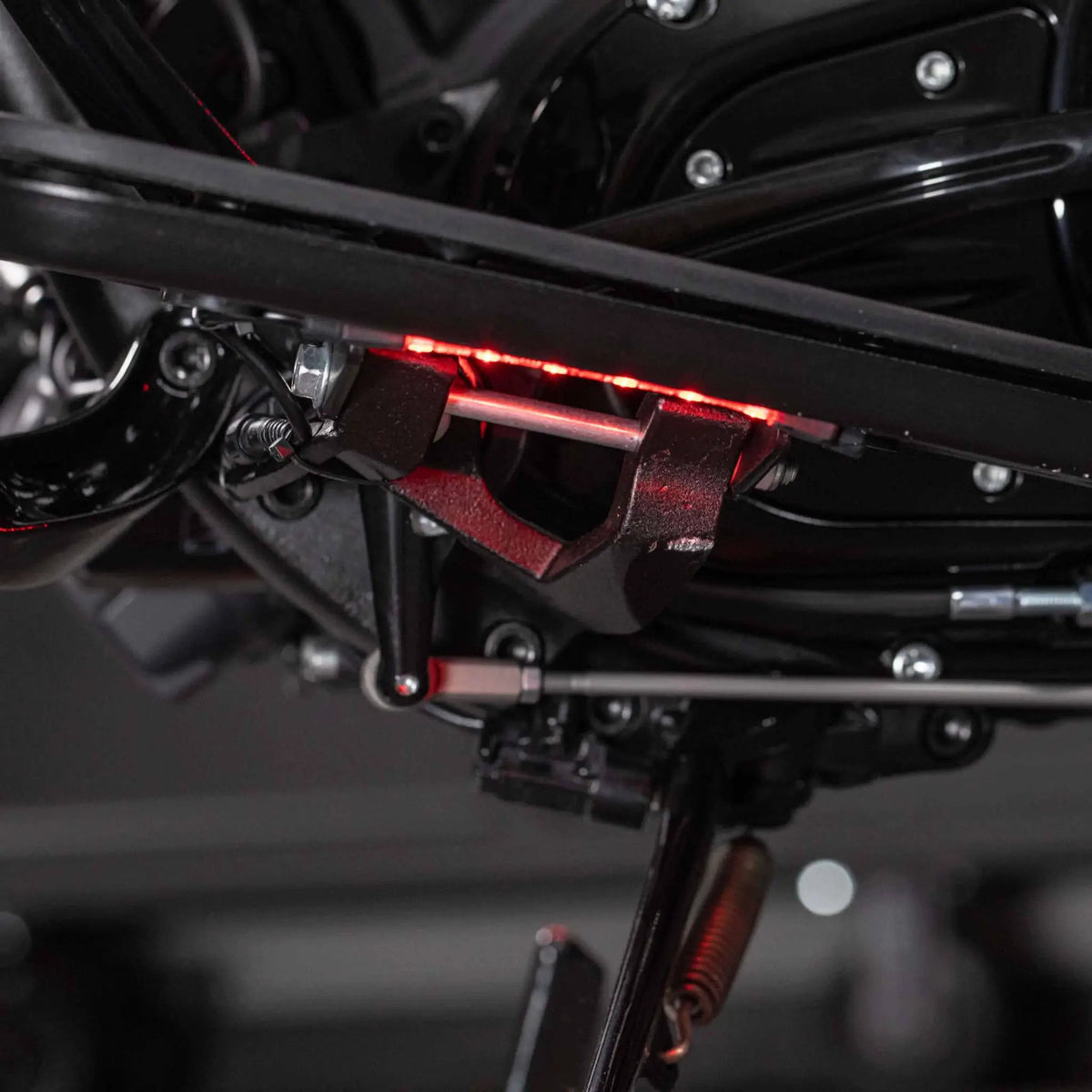 Red LED accent strip installed beneath a black motorcycle frame tube