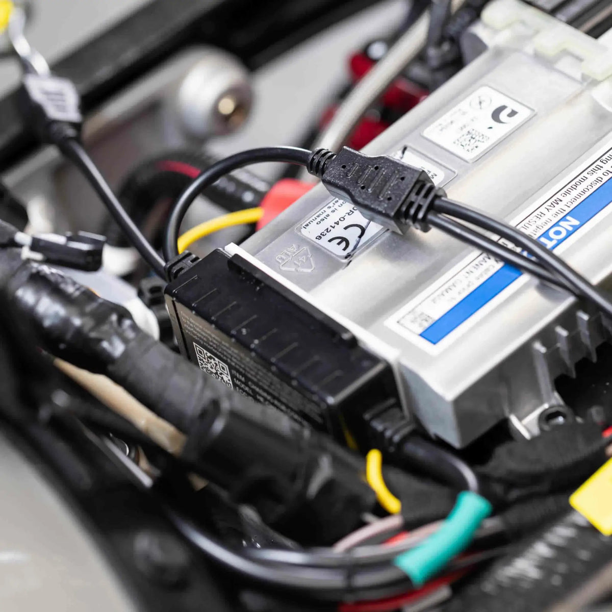 Motorcycle electrical compartment close-up showing connected lighting wires and plug connectors