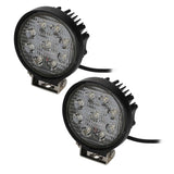 Pair of round LED driving lights with unlit lenses, finned housings and mounting brackets