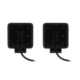 Rear view of two square driving lights with finned black housings and power cables