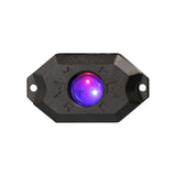 Black rock-light pod illuminated blue and purple, viewed from the front
