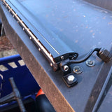 Close-up of a roof-mounted light bar's end bracket and power cable