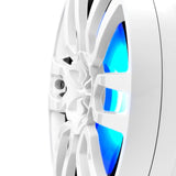 Close-up of a white pod speaker's sculpted grille and central tweeter with blue-cyan illumination.
