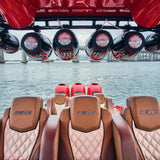 Marine tower speakers mounted overhead above the upholstered seating in a boat