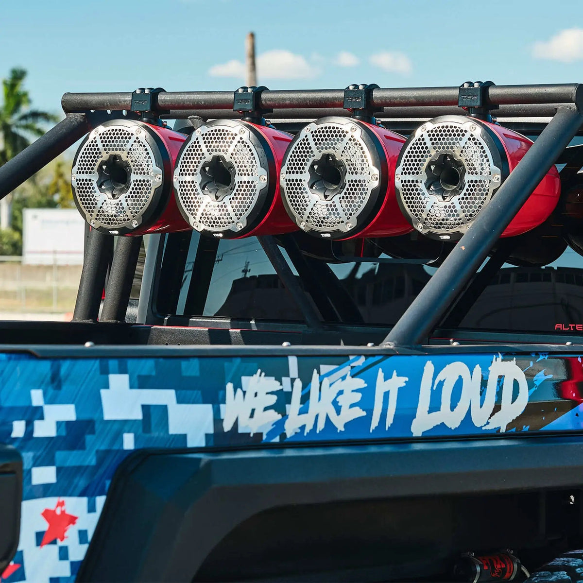 Four silver-grille tower speakers mounted across a vehicle's upper roll bar