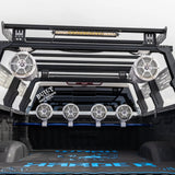 View into a vehicle's roll cage showing upper tower speakers, a light bar and a row of rear speakers