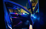 Car interior with multicolor ambient lighting across the dashboard and front doors