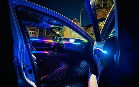 Car interior with multicolor ambient lighting across the dashboard and front doors