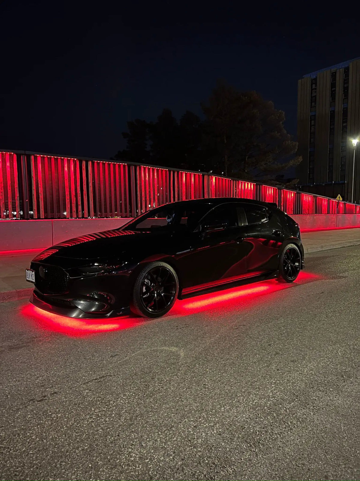 Black car at night with bright red underglow lighting