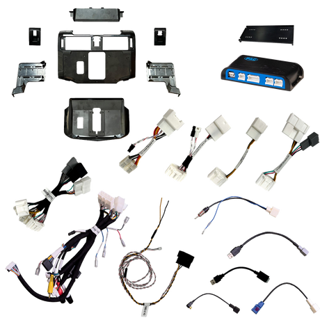 Radio installation components laid out with dashboard panels, brackets, an interface module, wiring harnesses and adapter leads