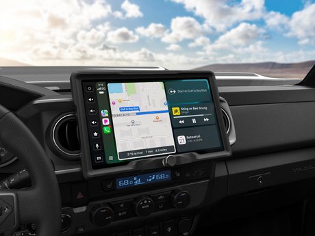 Dashboard touchscreen showing navigation, music playback and an upcoming calendar entry beside round air vents