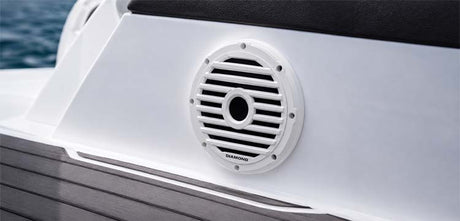 White marine speaker grille installed in a boat side panel above dark deck trim