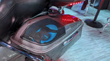 Motorcycle saddlebag with a blue-lit speaker beneath a black mesh grille