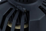 Close-up of a round four-pin connector beside a speaker basket