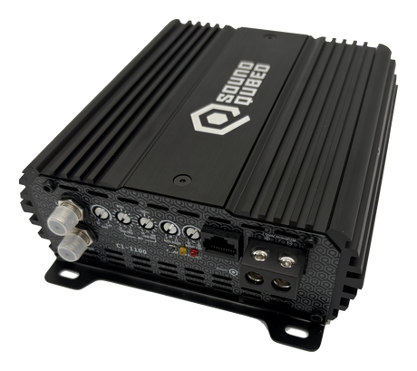 Angled view of a SoundQubed C1-1100 amplifier showing its input jacks, adjustment controls and speaker terminals