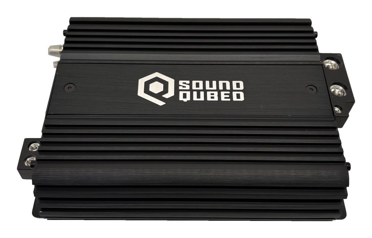 Top view of a black SoundQubed amplifier with cooling fins and terminal blocks visible at the sides