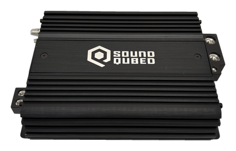 Top view of a black SoundQubed amplifier with cooling fins and terminal blocks visible at the sides