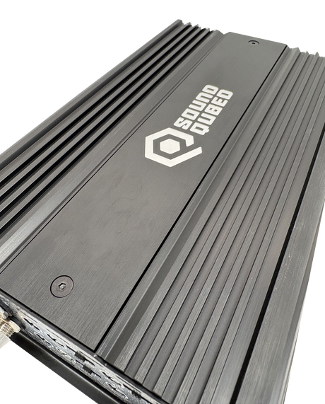 Close angled view of a SoundQubed amplifier's black top panel, white logo and longitudinal cooling fins