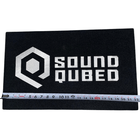 Tape measure across a black SoundQubed enclosure showing a width of approximately 22 inches