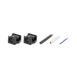 Angled view of two uncovered power distribution blocks with cable ends and a blue wire