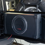 VIBE loaded subwoofer enclosure mounted to an open rear tailgate